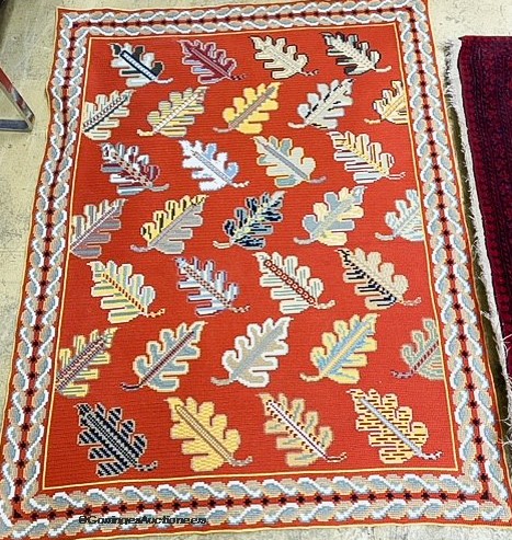 A red ground multi-coloured flat weave woollen rug with leaf decoration. 161 x 126cm.